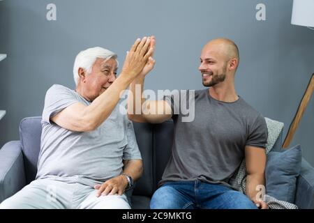 Joyeux grand-père qui donne le Grand cinq à son petit-fils Banque D'Images