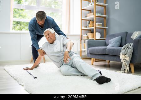 Aider l'aîné senior tombé homme après l'accident d'automne Banque D'Images