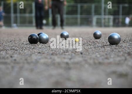 Boules de pétanque et petit jack jaune sur terrain de pétanque, Banque D'Images