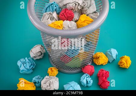 Des boules de papier froissé colorées dans une poubelle. Concept d'idée. Banque D'Images