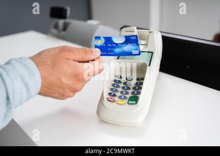 Le caissier de la boutique ou la femme à la réception de l'hôtel prend le paiement par carte de crédit Banque D'Images