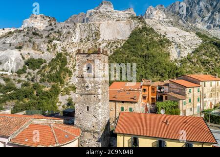 Vue aérienne du clocher de l'église Sant Bartolomeo dans l'ancien village de Colonnata et des Alpes Apuanes avec des carrières de marbre, Toscane, Italie Banque D'Images