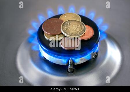 Cuisinière à gaz avec pièces de monnaie en flamme. Image conceptuelle de la hausse des prix. Banque D'Images