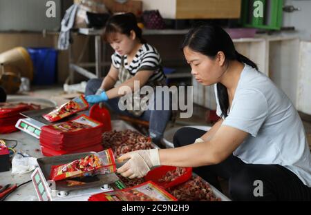 (200801) -- LIANYUNGANG, le 1er août 2020 (Xinhua) -- les travailleurs emballez des produits alimentaires vendus par des banderoles vivantes à la ville de Haitou à Lianyungang, dans la province de Jiangsu, en Chine orientale, le 30 juillet 2020. Suite au boom chinois des plates-formes de diffusion en direct et du commerce électronique, le commerce électronique en streaming en direct a connu un développement rapide et créé de nouvelles opportunités d'emploi. Dans la ville de Haitou, plus de 3,000 000 personnes ont passé à la vente en direct. Ces banderoles vivantes travaillent souvent de nuit à l'aube pour vendre des produits marins locaux et d'autres spécialités. Dans la journée, les marchandises vendues par streaming en direct seront envoyées à leur Banque D'Images