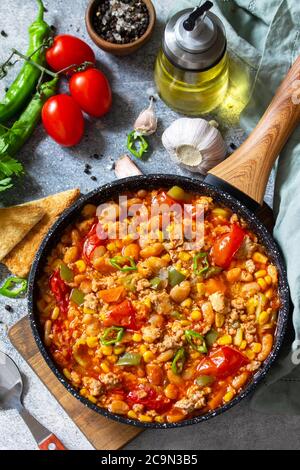Cuisine mexicaine traditionnelle. Chili con carne de viande, haricots et légumes sur table en pierre sombre. Banque D'Images