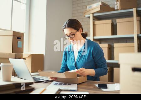 Femme travaille à l'entrepôt pour le vendeur en ligne. Concept de petite entreprise Web. Banque D'Images