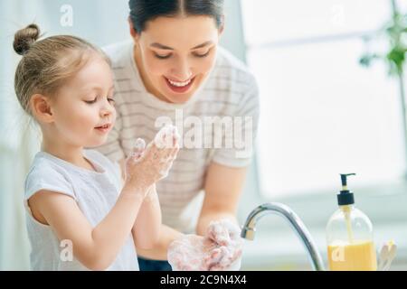 Une petite fille mignonne et sa mère se lavent les mains. Protection contre les infections et les virus. Banque D'Images