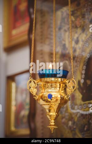 Lampe-icône bleu et or brûlante, bougie dans l'église sur un fond d'icône. Détails dans l'église chrétienne orthodoxe Banque D'Images