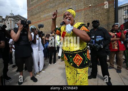 Une femme s'adresse aux manifestants qui soutiennent la campagne Halte à Maangamizi et le Comité de marche pour les réparations du jour de l'émancipation afrikan, avant de tenir un silence de trois minutes lors d'une manifestation sur la place Windrush à Brixton, Londres. Un couvre-feu et d'autres restrictions ont été imposés aux manifestations prévues dans le sud de Londres pour empêcher les personnes de bloquer les routes principales ou de planifier des événements musicaux illégaux, a déclaré Scotland Yard. Banque D'Images