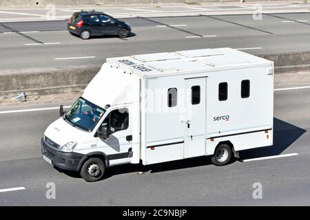 Vue aérienne face avant et toit de la fourgonnette de transport de prisonnier Iveco Et chauffeur exploité par Serco public transport affaires conduite le long de l'autoroute britannique Banque D'Images