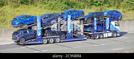 Ford Motor Company camion camion camion camion livraison transporteur et remorque chargé de neuf nouvelles voitures bleues non enregistrées conduite sur la route d'autoroute du Royaume-Uni Essex Angleterre Banque D'Images