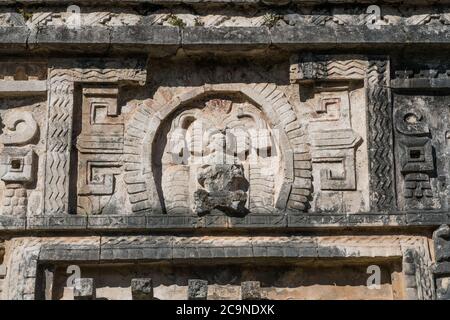 Une figure de relief en pierre sculptée sur la façade du complexe Nunnery dans les ruines de la grande ville maya de Chichen Itza, Yucatan, Mexique. Banque D'Images