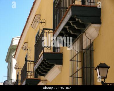 Balcons sur bâtiment jaune avec des rampes en fer forgé noir, la Havane Banque D'Images