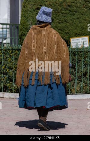 COPACABANA, BOLIVIE - 24 JUILLET 2016 : une femme bolivienne non identifiée portant une casquette de laine et un poncho tissé traditionnel marche autour de la place en Co Banque D'Images