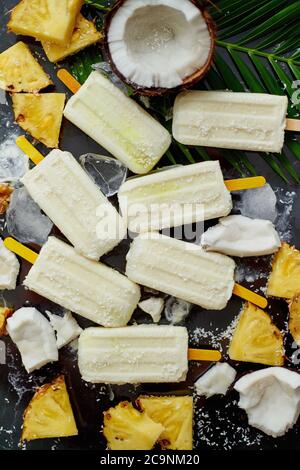 Des popsicles d'été sur le bâton. Saveur PinaColada. À base d'ananas, de lait de coco et de rhum. En-cas végétalien Banque D'Images