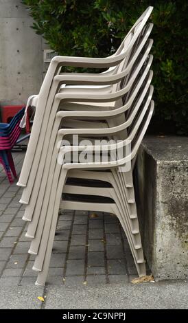 Une pile de chaises empilables ou emboîtables en plastique à vendre à l'extérieur d'un magasin de quincaillerie Banque D'Images