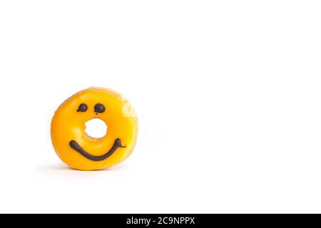 Beignet jaune frais avec un sourire au chocolat manquant morsure isolée sur fond blanc avec une ombre molle Banque D'Images