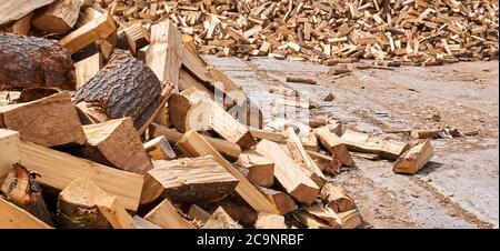 une énorme pile de cales de bois de chauffage repose sur le béton extérieur Banque D'Images