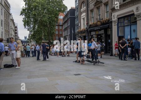 Les employés de la ville apprécient de boire au pub Sugarloaf tout en dehors socialement distancé le vendredi soir d'été sur Queen Street, Londres, EC4 Banque D'Images