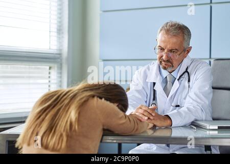 Une jeune femme pleure à l'audition d'un diagnostic défavorable à la nomination d'un médecin Banque D'Images