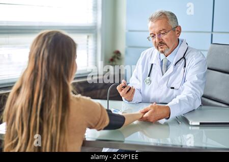 Jeune femme au rendez-vous avec le médecin. Le médecin mesure la pression du patient Banque D'Images