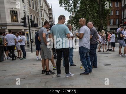 Les employés de la ville apprécient de boire au pub Sugarloaf tout en dehors socialement distancé le vendredi soir d'été sur Queen Street, Londres, EC4 Banque D'Images