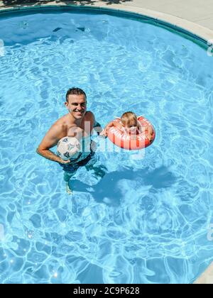 Budva, Monténégro - 01 août 2020 : papa et fille nagent dans la piscine. Banque D'Images