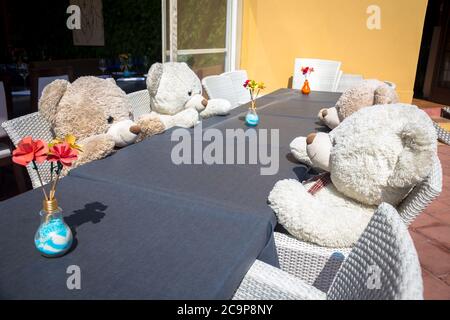 Un groupe d'ours Teddy assis à une table et prêt pour un déjeuner ou une réunion Banque D'Images