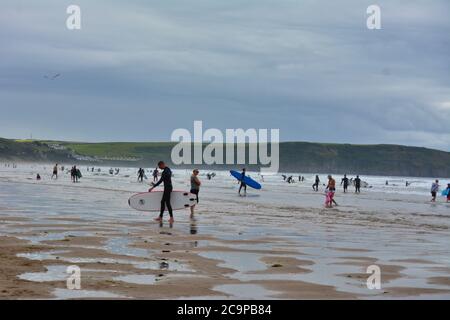 Surfeurs sur la belle plage de Woolacombe Banque D'Images
