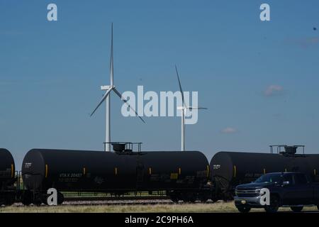 Harrold, Texas, États-Unis. 31 juillet 2020. Les éoliennes Harrold tournent comme un cric à pompe qui tire du pétrole dans l'ouest du Texas le 31 juillet 2020. Le Texas est le plus grand producteur d'énergie éolienne des États-Unis. Crédit : Bryan Smith/ZUMA Wire/Alay Live News Banque D'Images