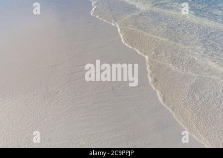 Vague douce d'océan bleu sur fond de plage de sable. Mise au point sélective. Banque D'Images