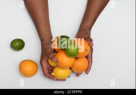 FÊTE DES AGRUMES : une collection d'oranges, de limes et de citrons est disposée dans une couche plate sur un fond blanc pur. Banque D'Images