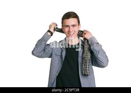 Un jeune homme dans une chemise de Manatee, un t-shirt et un pantalon noirs, isolés sur des robes blanches. Une écharpe à carreaux est nouée Banque D'Images