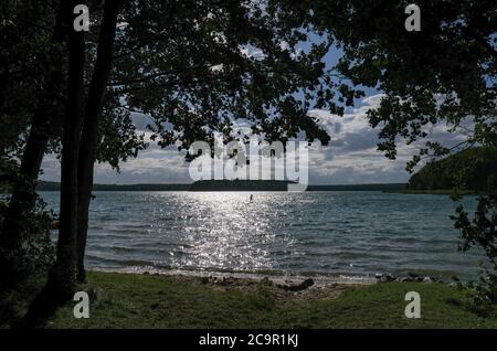 Neuglobsow, Allemagne. 29 juillet 2020. Le Großer Stechlinsee en fin d'après-midi avec le soleil bas dans le ciel, qui crée la paillettes sur l'eau. Il fait partie du parc naturel de la terre de Stechlin-Ruppiner, appartient au district du lac de Rheinsberg dans la zone naturelle de la Neustrelitzer Kleinseenland, est connu pour sa bonne qualité de l'eau et à 70 mètres est le lac le plus profond de Brandebourg. Credit: Jens Kalaene/dpa-Zentralbild/ZB/dpa/Alay Live News Banque D'Images