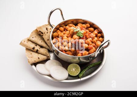 Curry épicé de pois chiches, Chana Masala ou Choley dans un bol avec chapati et salade. Plat traditionnel indien du Nord. Banque D'Images