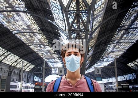 Jeune homme à la gare avec masque facial. Gros plan. Banque D'Images