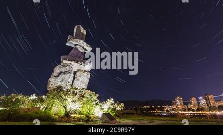 Inukshuk au parc Stanley, à la plage de la baie English, à Vancouver, en Colombie-Britannique, au Canada, en Amérique du Nord la nuit avec des pistes étoiles Banque D'Images