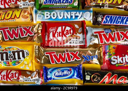 Ukraine, Kiev - 23 mars 2020 : un bouquet de barres de chocolat, dont des Snickers, Twix, Milka, KitKat, Lion, M&M, Bounty, sur fond jaune. Banque D'Images