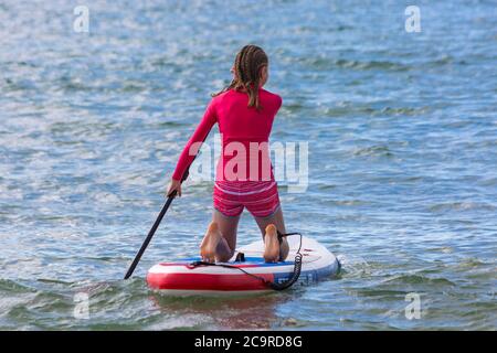 Poole, Dorset Royaume-Uni. 2 août 2020. Météo au Royaume-Uni : belle journée chaude et ensoleillée sur les plages de Poole, les températures grimpent et les amateurs de soleil affluent en bord de mer pour profiter du temps ensoleillé. Paddleboarder. Crédit : Carolyn Jenkins/Alay Live News Banque D'Images