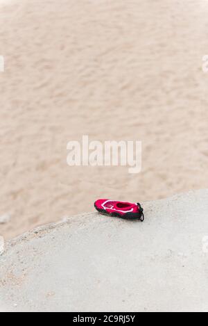 Une chaussure de plage pour enfants est restée sur le mur à Fistral Beach à Newquay, en Cornouailles. Banque D'Images