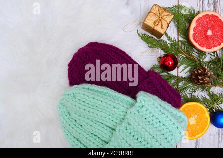 Le concept de la nouvelle année. Deux chapeaux tricotés, agrumes et décorations pour arbres de Noël. Espace pour le texte Banque D'Images