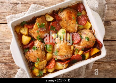 Poulet traditionnel espagnol avec pommes de terre neuves et saucisse chorizo dans un plat de cuisson sur la table. Vue horizontale du dessus Banque D'Images