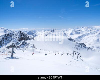 Vue panoramique depuis le sommet de Wildspitze sur le paysage d'hiver avec des pistes de montagne enneigées et des pistes et des skieurs sur télésiège à Stubai Gletscher ski r Banque D'Images