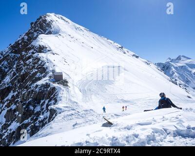 Glacier de Stubai, AUTRICHE, 2 mai 2019: Snowboardeur assis et reposant au sommet de la montagne Schaufelspitze à la station de ski de Stubai Gletscher. Poulailler Banque D'Images