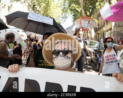 Madrid, Espagne. 2 août 2020. Une femme tenant une bannière défendant le marché aux puces 'Rastro' et portant un masque qui se lit en espagnol: 'Nous sommes Rastro'. © Valentin Sama-Rojo/Alamy Live News. Banque D'Images