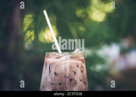 Gros plan sur les boissons rafraîchissantes de l'été. Cacao au chocolat glacé réfrigéré. Poudre de chocolat et glace. Dans des verres, avec des tubes pour boire. Feuilles vertes nature b Banque D'Images