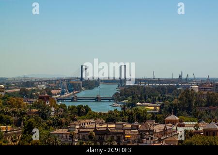 Une vue aérienne du paysage urbain de Séville, en Espagne. L'image présente des bâtiments historiques, des palmiers dattiers, des sites de construction avec grues, Guadalquivir ri Banque D'Images
