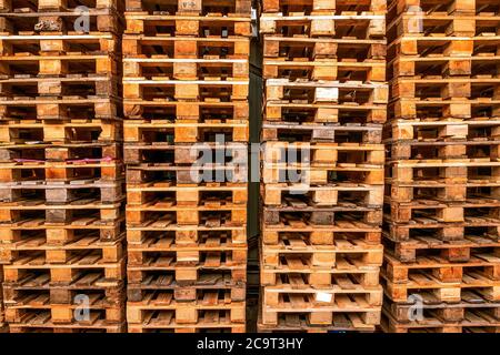 De nombreuses piles de palettes en bois d'occasion de type euro en entrepôt sont prêtes pour le recyclage. Contexte industriel. Gros plan. À L'Extérieur. Banque D'Images