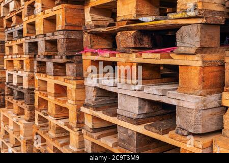 De nombreuses piles de palettes en bois d'occasion de type euro en entrepôt sont prêtes pour le recyclage. Contexte industriel. Gros plan. À L'Extérieur. Banque D'Images