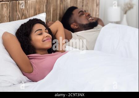 Couple africain détendu appréciant leur nouveau lit Banque D'Images